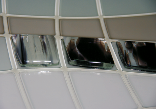 Detalle fusing Azulejos de diferentes colores y texturas en un patrón geométrico.