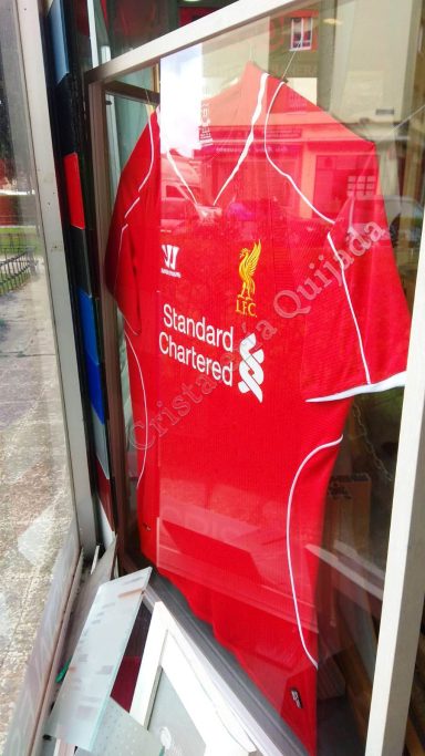 Liverpool. Camiseta de futbol. Camiseta roja del Liverpool exhibida en la tienda, con logotipos y patrocinador.