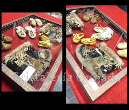 Enmarcado para su protección. Acervo cultural de los indios Hurones. Indios Hurones. Botas y mocasines enmarcados para su conservación y exposición. Pertenecientes a tres generaciones, abuela, madre e hijos.