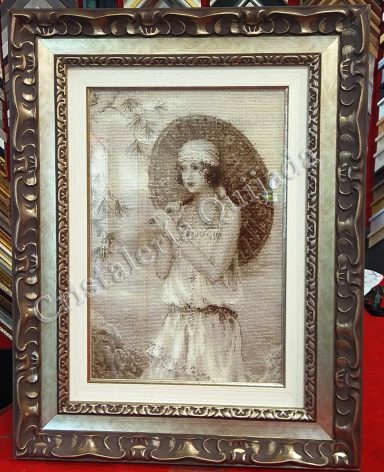 Punto de cruz. Dama con sombrilla. Trabajo enmarcado de punto de cruz.