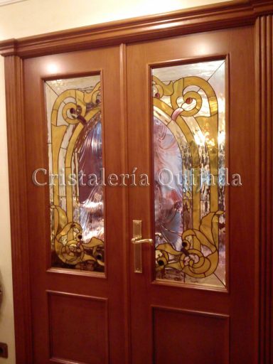 Vidriera artesana Puerta de madera con vidrieras decorativas en tonos cálidos.